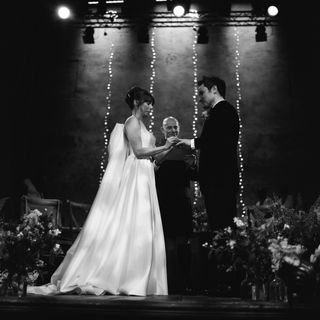 Image may contain Clothing Apparel Lighting Human Person Fashion Robe Gown Wedding Suit Coat Overcoat and Dress