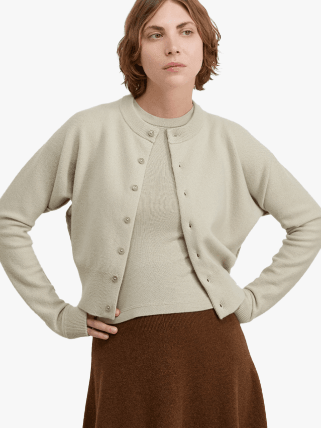 Image may contain Clothing Knitwear Sweater Cardigan Adult Person Shirt Face Head and Skirt